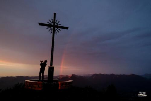 Regenbogen, Gipfelkreuz und Fotografin